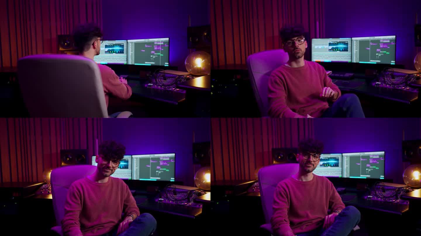 男录音师使用电脑屏幕的后视图，显示带有音轨的软件界面