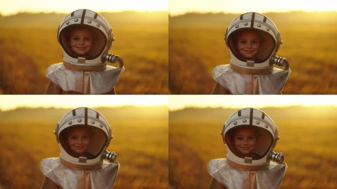 小宇航员男孩的肖像看着相机和微笑，孩子戴着大太空头盔