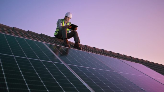男子，屋顶和太阳能电池板安装与平板电脑，技术和房子在日落清洁能源工作。可持续，电力或电工和承包商在晚