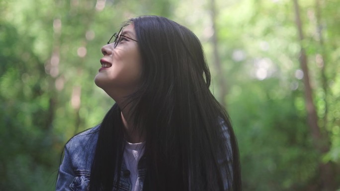 徒步旅行者有吸引力的快乐的年轻女孩背着背包在山上徒步旅行，周围都是令人惊叹的风景