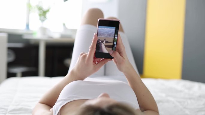 一个女人躺在沙发上翻看手机里的照片