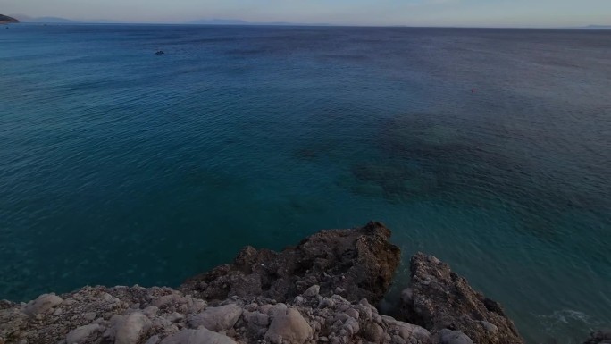 广阔的深蓝色大海延伸沿着岩石海岸线在一个全景的远景，邀请和平的反思和宁静在阿尔巴尼亚