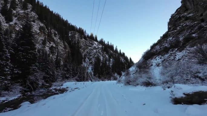 在雪地上的车辙上行进，穿过狭窄的峡谷，在布满云杉林的冬季岩石中穿行