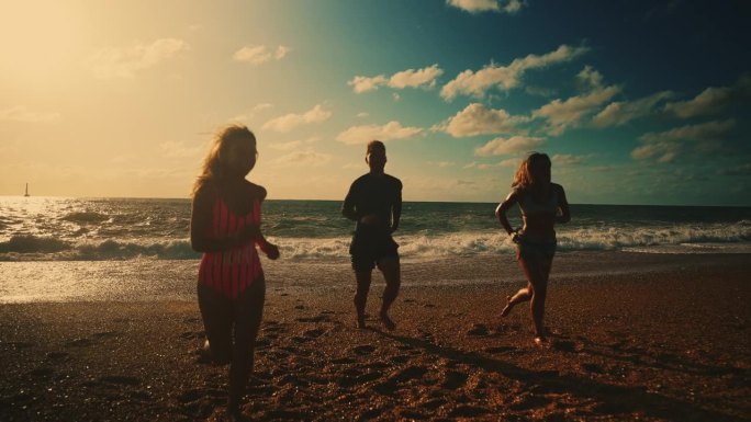 在阳光明媚的海滩上，无忧无虑的朋友在沙滩上奔跑