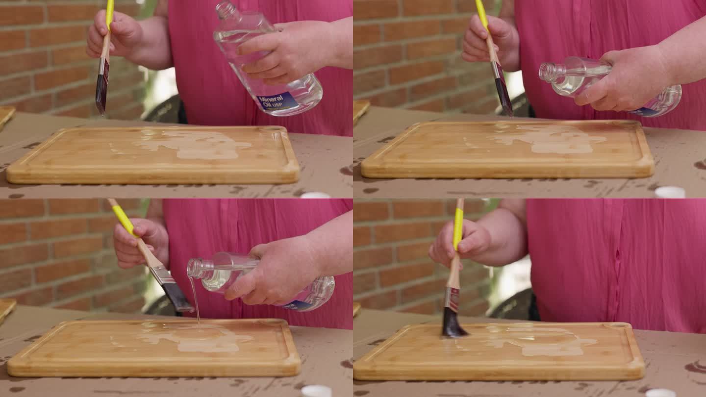 木质砧板寿命长。模糊的女人用画笔做木工，从瓶子里倒油。用刷子把注意力集中在手上。近距离
