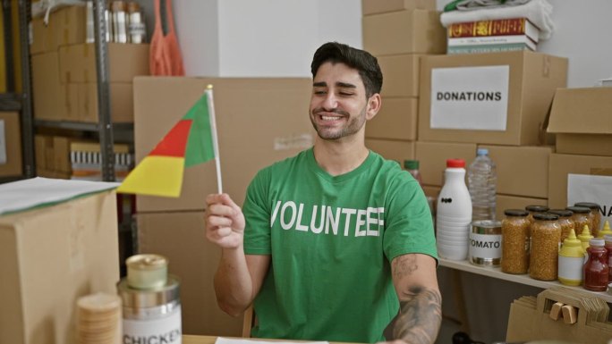 在慈善中心，年轻的西班牙裔志愿者面带微笑，自信地举着喀麦隆国旗