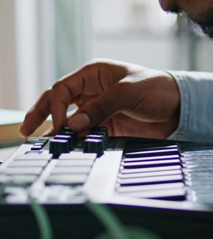 男子手臂使用键盘家用垂直特写。匿名dj触摸控制台