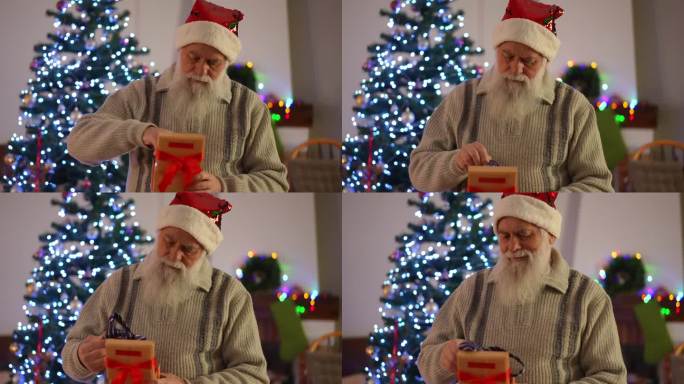 一位留着胡子、头戴圣诞帽的老人在圣诞树的背景上打开礼物。我们看到礼品盒里系着一条红丝带的男士领带。