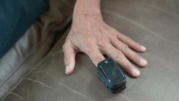 一位老人用指尖血氧计检查哮喘症状。