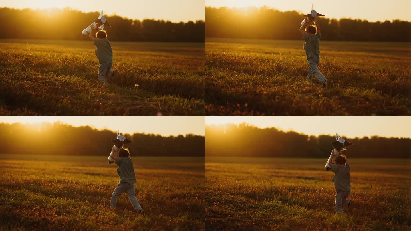快乐的夏日乡村，小男孩带着玩具火箭在夕阳下的田野里奔跑，慢动作
