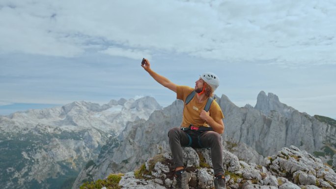 一名男子在登山后在山顶上使用智能手机