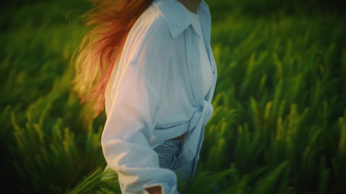 日落时分，兴奋的女子在绿色的小麦地里奔跑