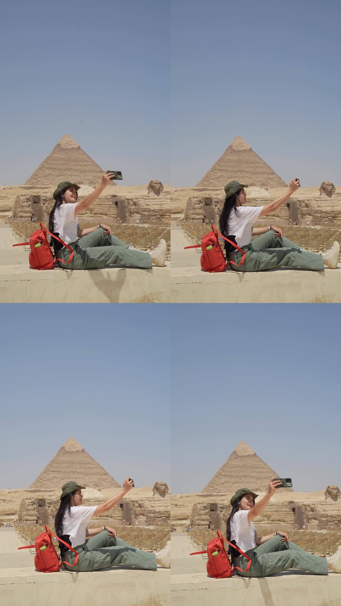 埃及，开罗，亚洲女游客拍摄吉萨大金字塔的背景