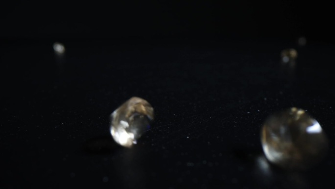 闪亮的钻石落在工作室黑暗的桌子上