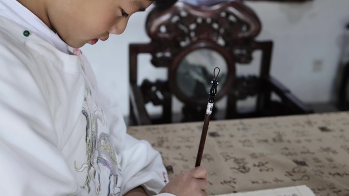 可爱的汉服男孩在写毛笔字
