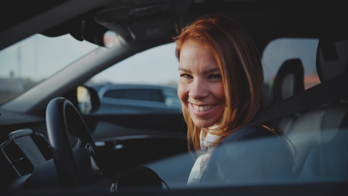肖像微笑的女人打开停放的车窗