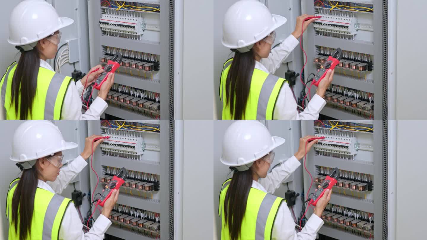 电工工程师工作测试仪，用于测量电气控制柜中电力线路的电压和电流。电力和电气维修服务。