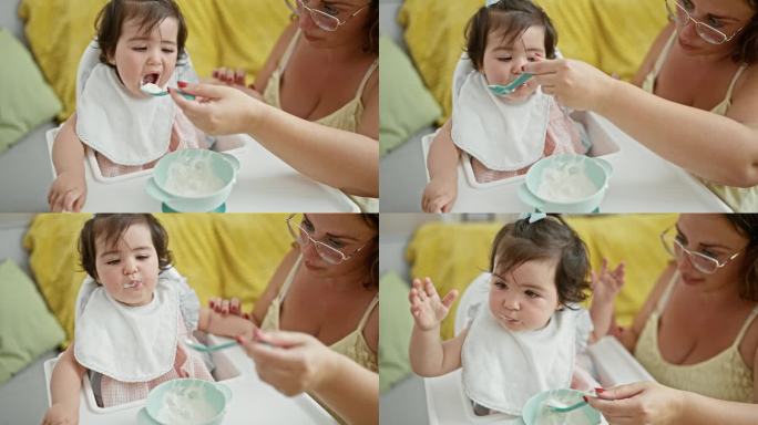 母女俩在一起，热爱家庭生活方式，在宝宝吃午饭的时候，随意地坐在家里，拿着勺子和围兜，专心地在客厅里吃