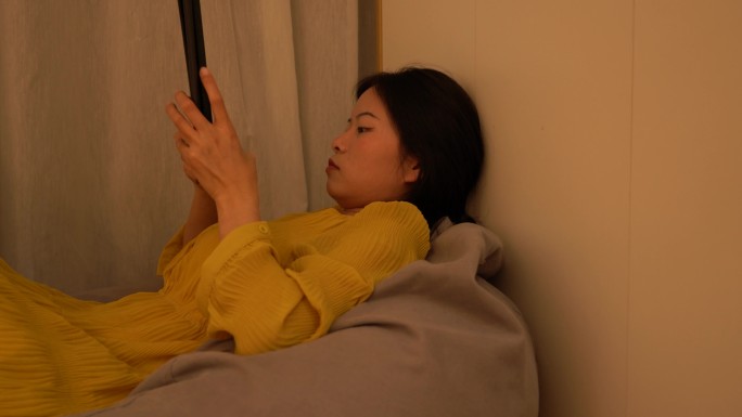4K独居女性无聊躺在懒人沙发玩平板电脑