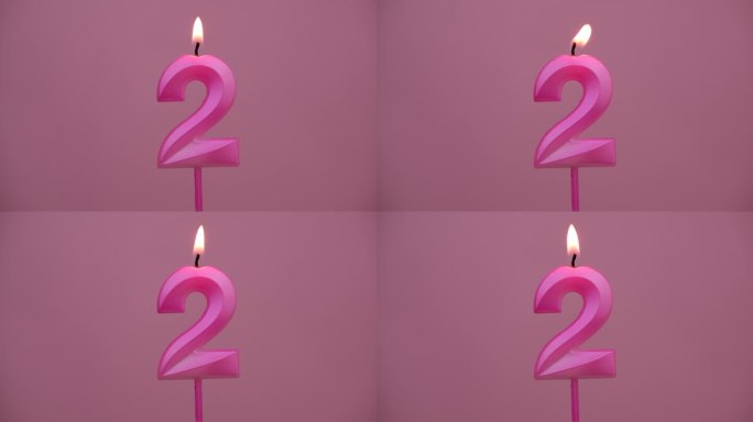 燃烧的生日蜡烛在粉红色的背景，2号。文本空间