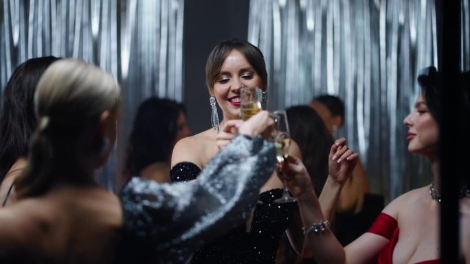 女士们在圣诞和新年聚会上点击眼镜，一群女性朋友喝香槟