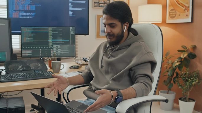 微笑的男程序员用笔记本电脑在家里进行视频通话