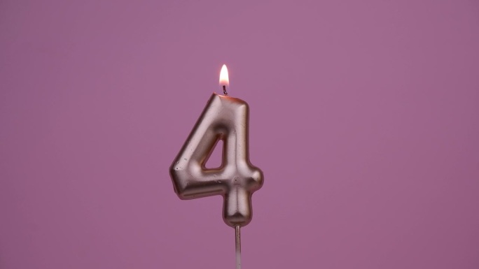 生日蜡烛在4号的粉色上燃烧。