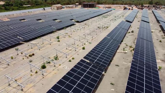 在西非冈比亚，正在建设中的Jambur太阳能发电厂，空中低空滑过清洁的光伏阵列