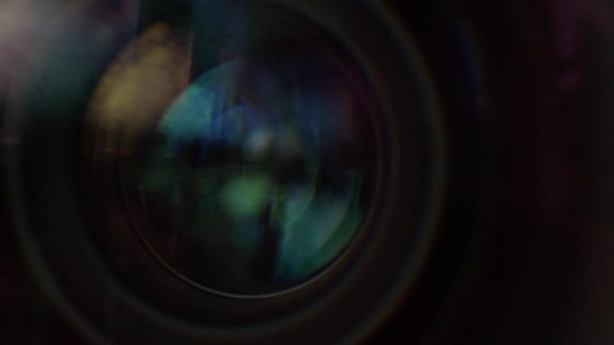电影镜头的虹膜打开和关闭的微距镜头。窗式反射在镜片上，不同的镜片涂层可见。