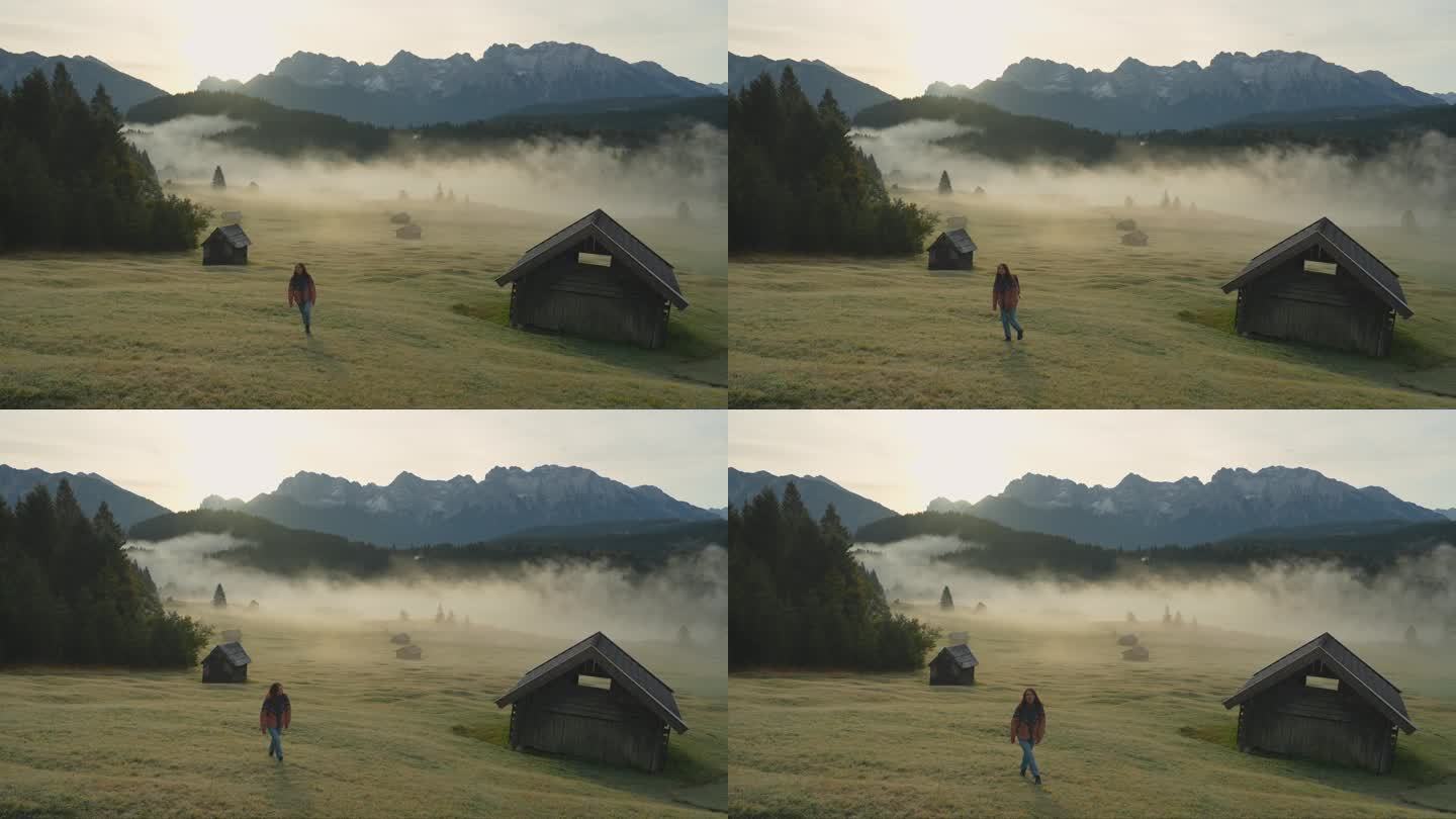 一个女人在巴伐利亚阿尔卑斯山的浓雾中行走