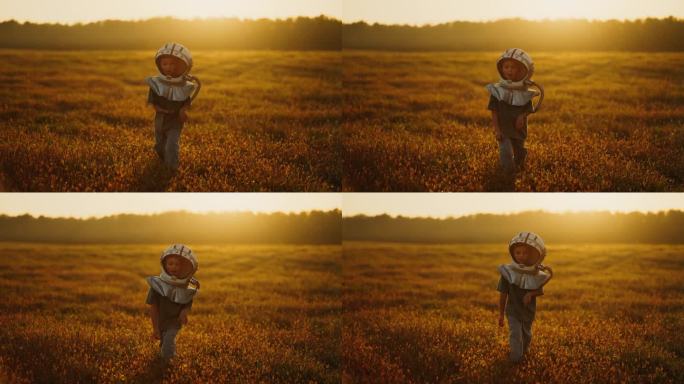 夏天，无忧无虑的小男孩戴着太空人服头盔在野外玩耍