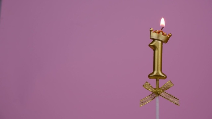 金色生日蜡烛燃烧在粉红色，1号。