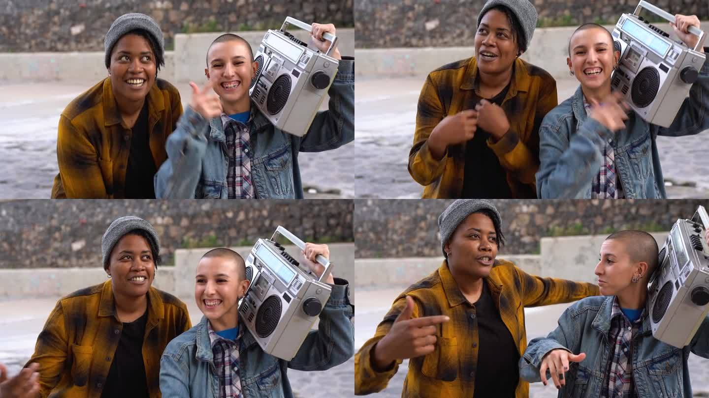 年轻的多种族女性街头音乐家在城市里说唱和跳舞-秃顶的女孩拿着老式的boombox