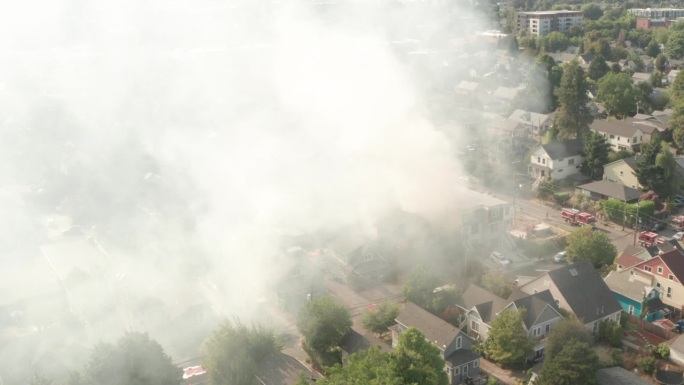 盘旋的空中镜头穿过房屋火灾的烟雾