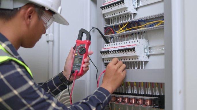 电工工程师工作测试仪，用于测量电气控制柜中电力线路的电压和电流。电工维修工作。