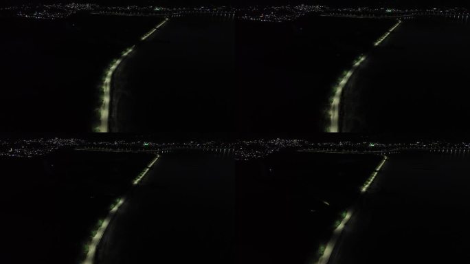 夜间无人街道的鸟瞰图。鸟瞰印尼哥伦塔洛林波托湖边缘的一排路灯