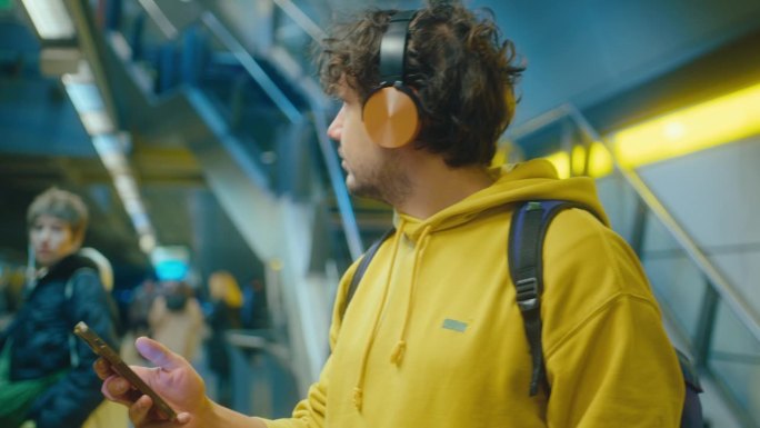 戴耳机的男子在地铁里使用手机和振动