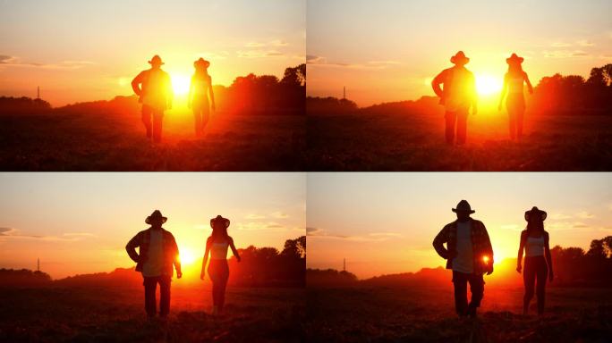 两个戴草帽的农民的剪影，在红色的夕阳下走过耕地。夫妻俩经营家族农业企业。合作伙伴散步和检查他们的农村