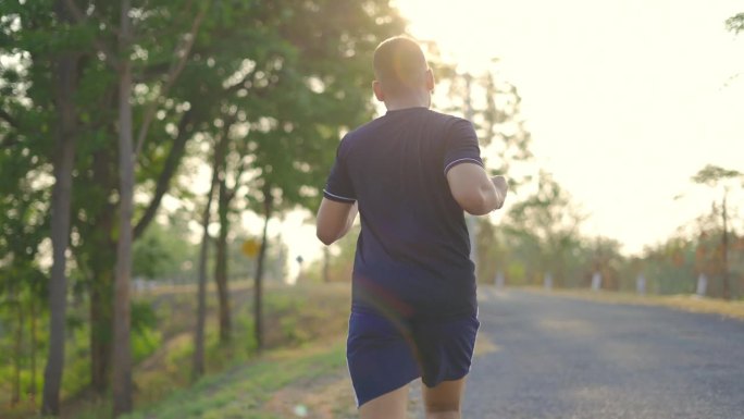 运动人男孩在日落时分独自跑在山附近进行运动训练。