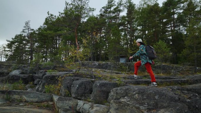 电影拍摄与女旅行者走在悬崖上的大石头，史诗慢动作，背包客