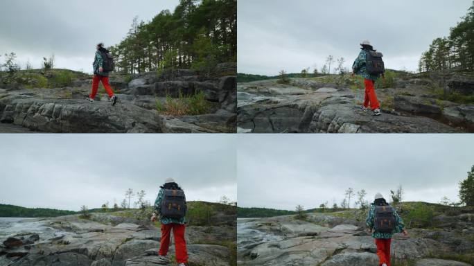 女游客背着背包走在石头上，欣赏自然之美、旅游之美、背包之美