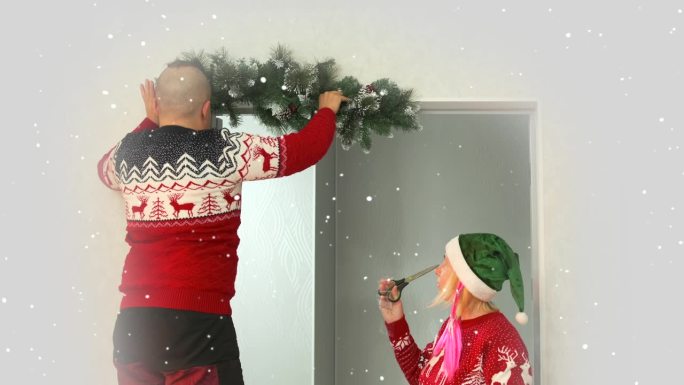 年轻夫妇男女准备圣诞节用冷杉树枝装饰门口，