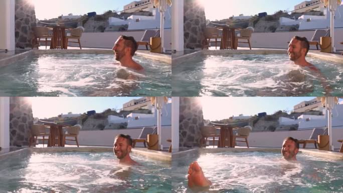 慢镜头:一名男子在他的度假屋户外的私人热水浴缸里放松