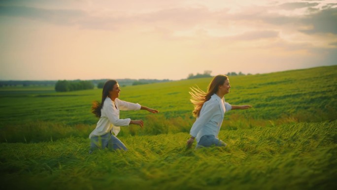 嬉戏的朋友们在橙色的天空下，在麦田里的绿色庄稼中奔跑