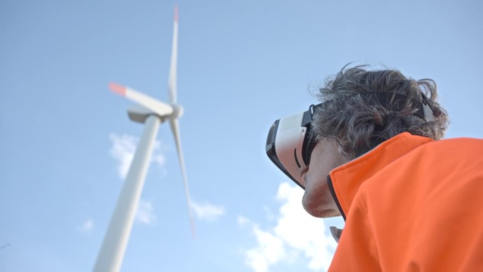 戴着VR眼镜的工程师在风电场工作。AR工具概念。