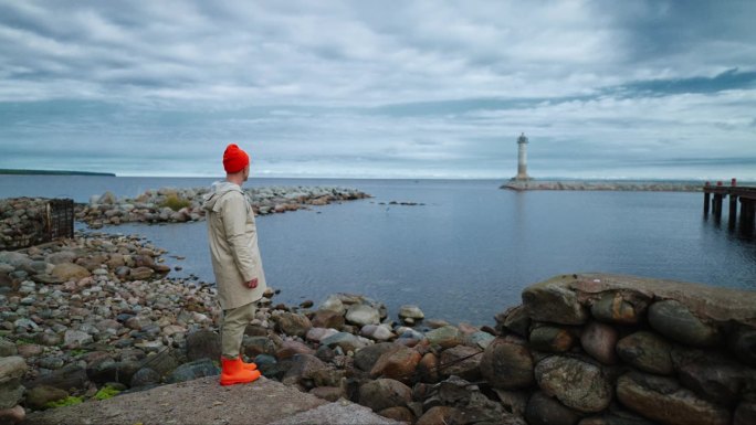 清晨，挪威水手或渔夫独自站在美丽的海湾海岸