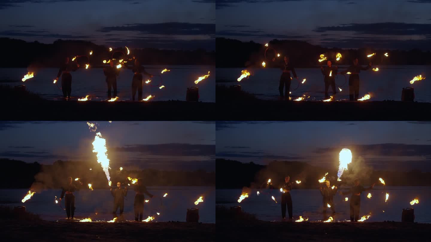 户外马戏表演，夜晚河滩上令人惊叹的火焰表演和旋转燃烧的火炬