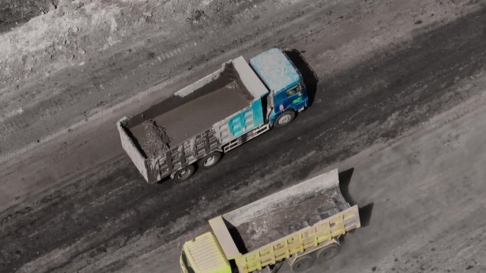 煤矿开采-载满泥浆的自卸卡车在矿区行驶的鸟瞰图。