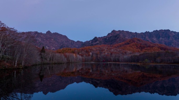 鸟居高地鸟居山的时间流逝，秋天的树叶沐浴在早晨的阳光中，反射在神池里