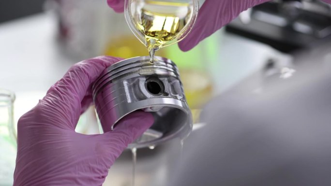 科学家化学家在实验室将发动机油倒在汽车活塞上，特写4k电影慢动作